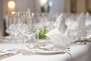 Close up of dinner table decoration with white linen and silverware