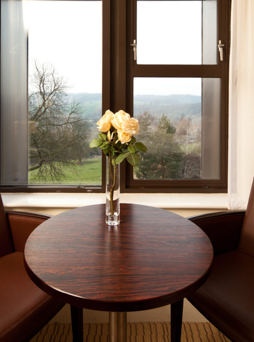Table and chairs in front of a window overlooking the grounds at Mercure Bradford Bankfield Hotel