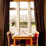 Dining table with garden views in The Brasserie restaurant at Mercure Bradford Bankfield Hotel