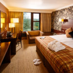 Double bed, desk, table and chairs in a superior room at Mercure Bradford Bankfield Hotel