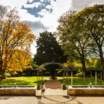 Wide shot of mercure bradford bankfield hotel's garden with archway, ponds and large trees