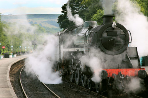 A steam locomotive gathers steam at Grosmont Station on the North York Moors Railway.