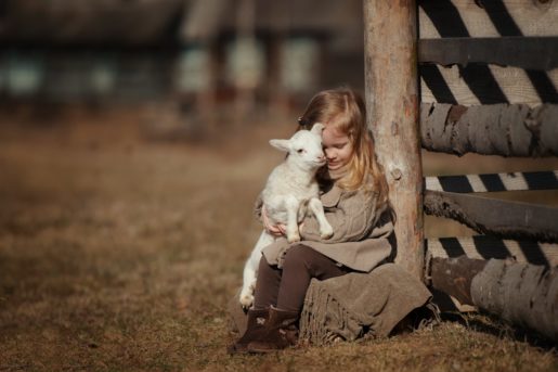 Girl sat with a little lamb